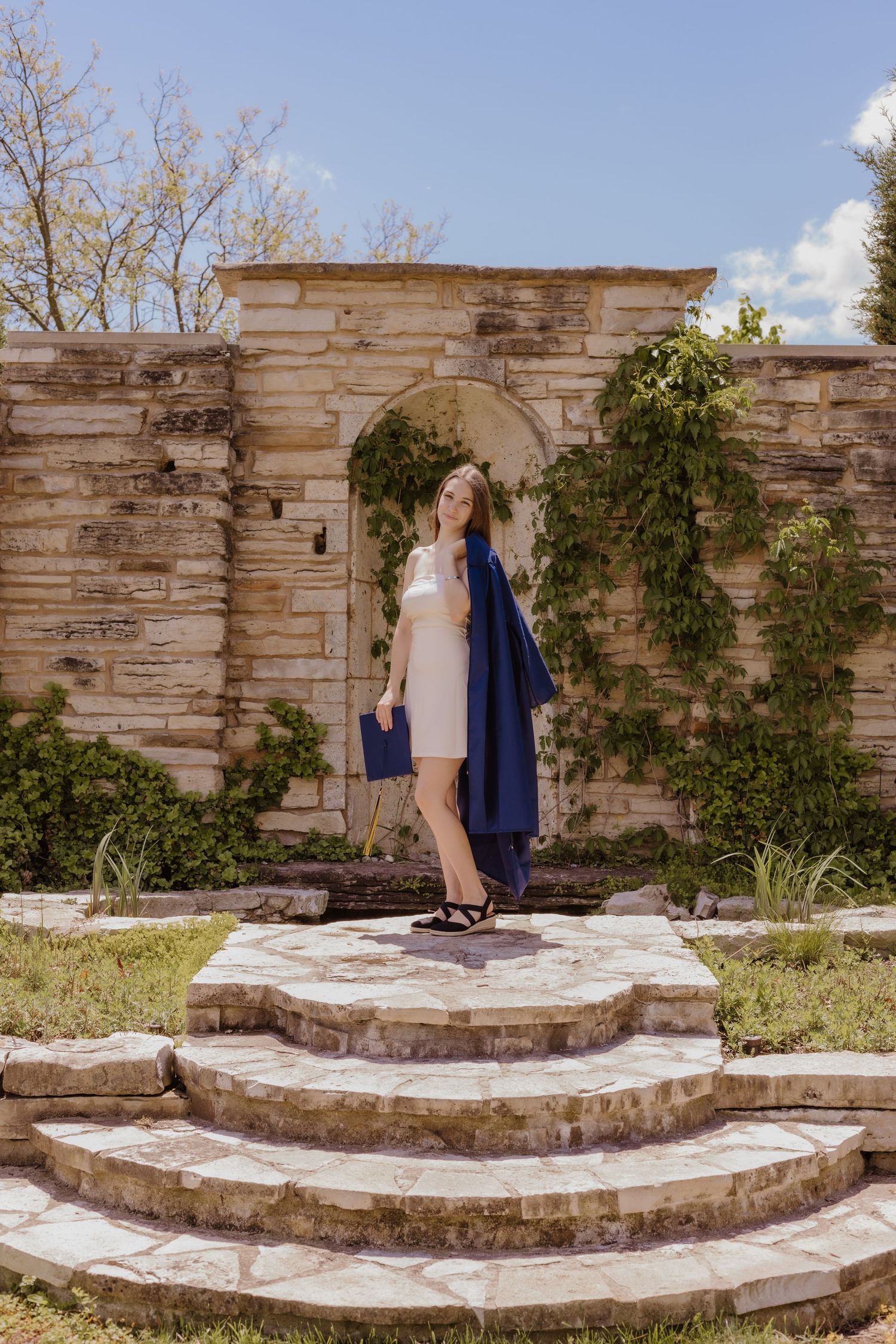 A series of four sequential images showing two people walking up stone garden steps next to a rustic stone wall.