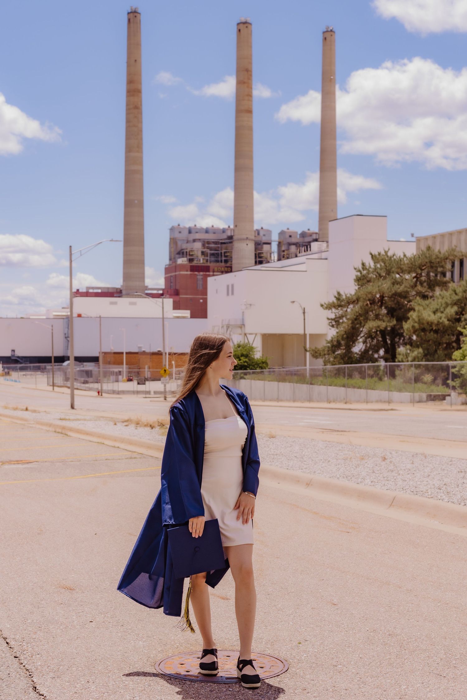 A sequence of photos showing someone in a navy blazer walking across an industrial area with tall smokestacks in the background.
