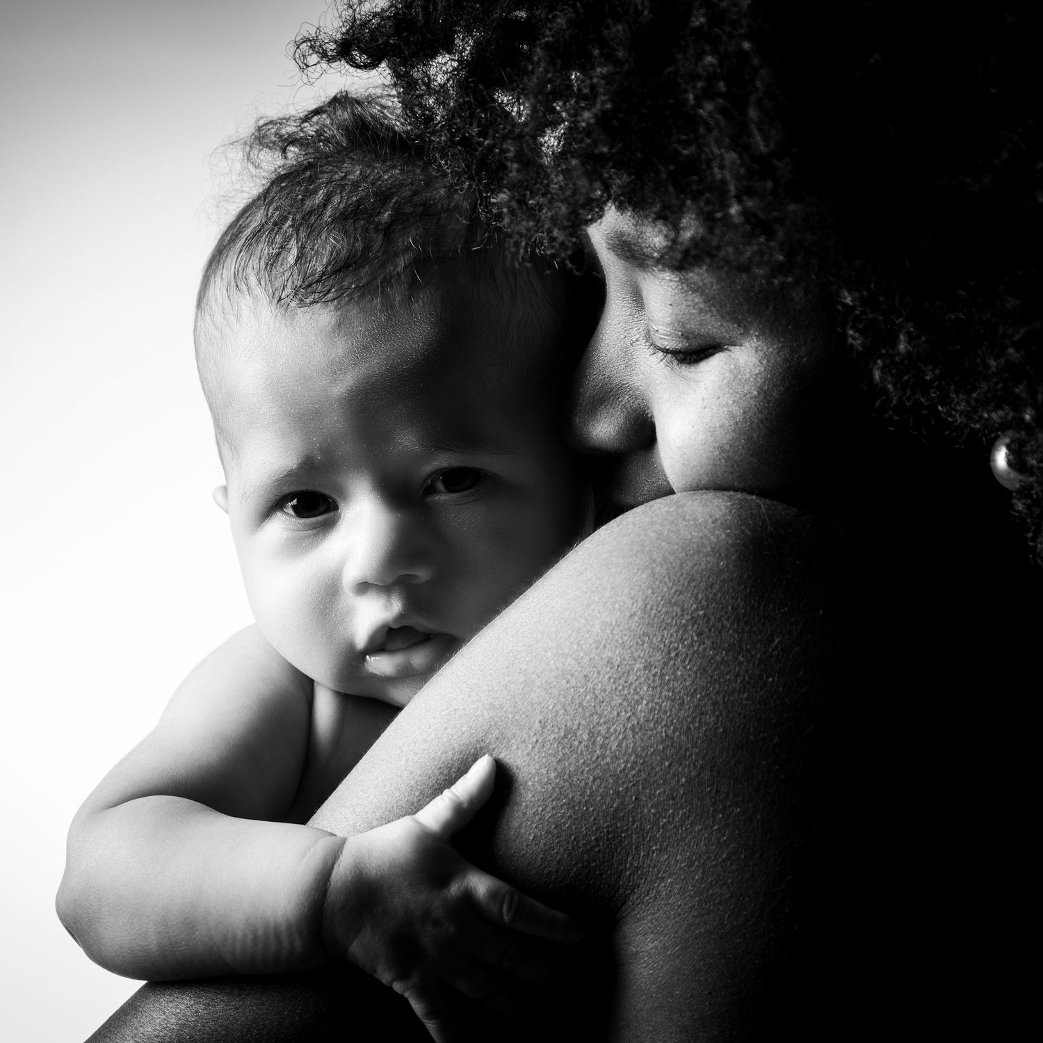 Ein ganz intimer Moment zwischen Mutter & Baby. Das Baby schmiegt sich in den Arm der Mutter. Fotografiert im Fotostudio in Gelsenkirchen