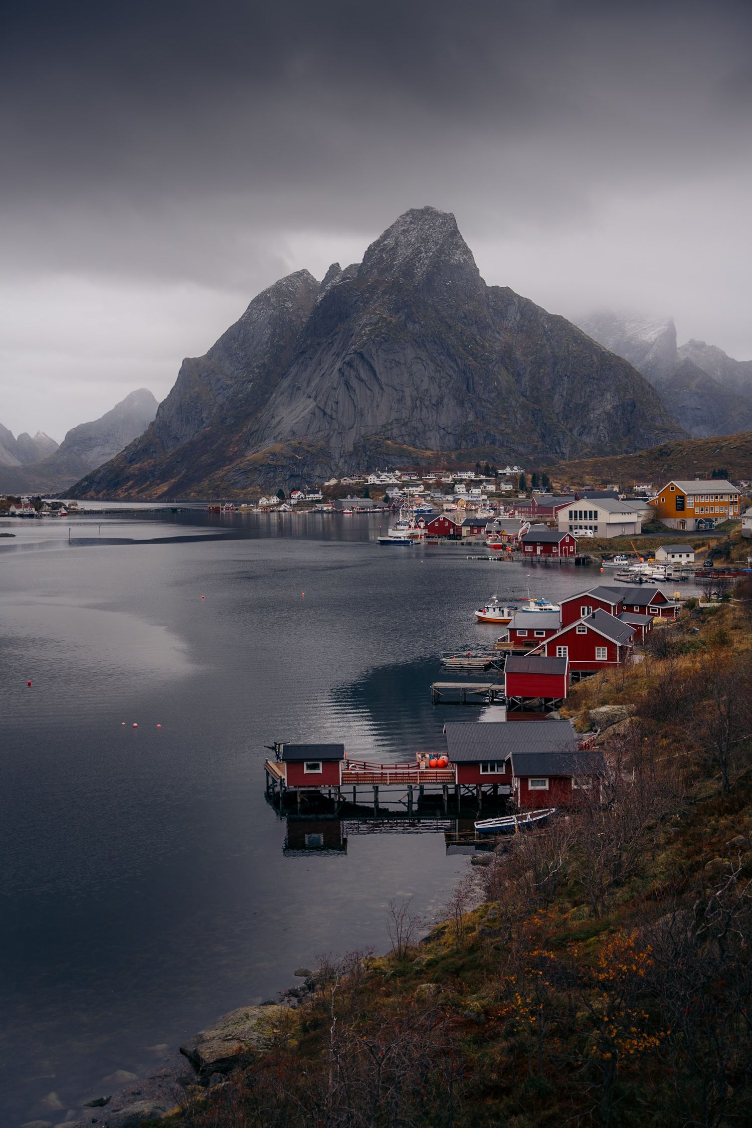lofoten reine avec ciel couvert, montagne et rorbu sous les couleurs d'automne