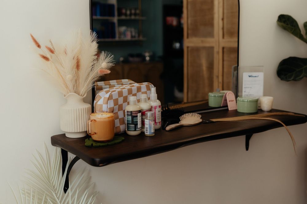 Wooden floating shelf decorated with dried pampas grass, candles, and home decor items in a cozy interior setting.
