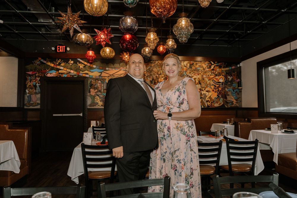 Festive restaurant interior with hanging gold sphere ornaments and white tablecloths creating an elegant dining atmosphere.