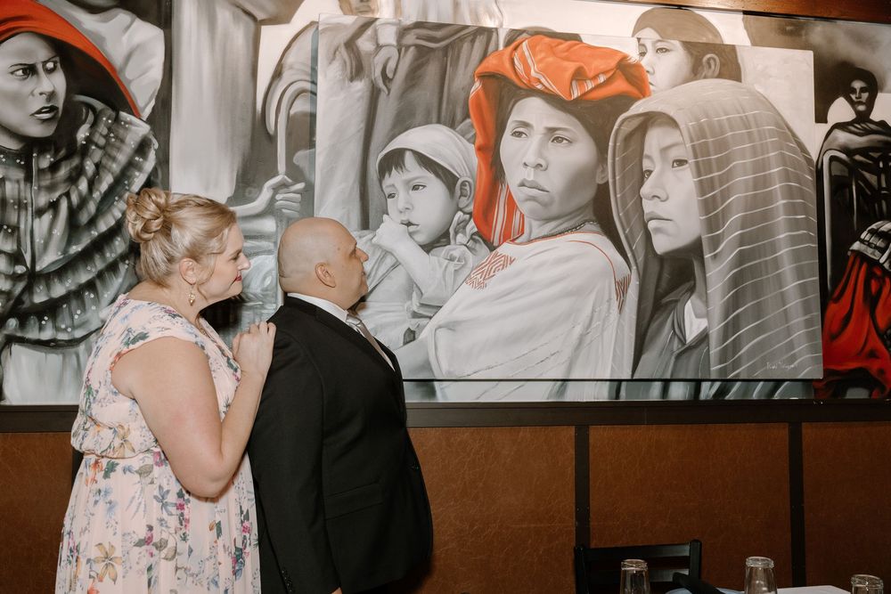 Black and white photographs line the walls of an intimate restaurant dining space.