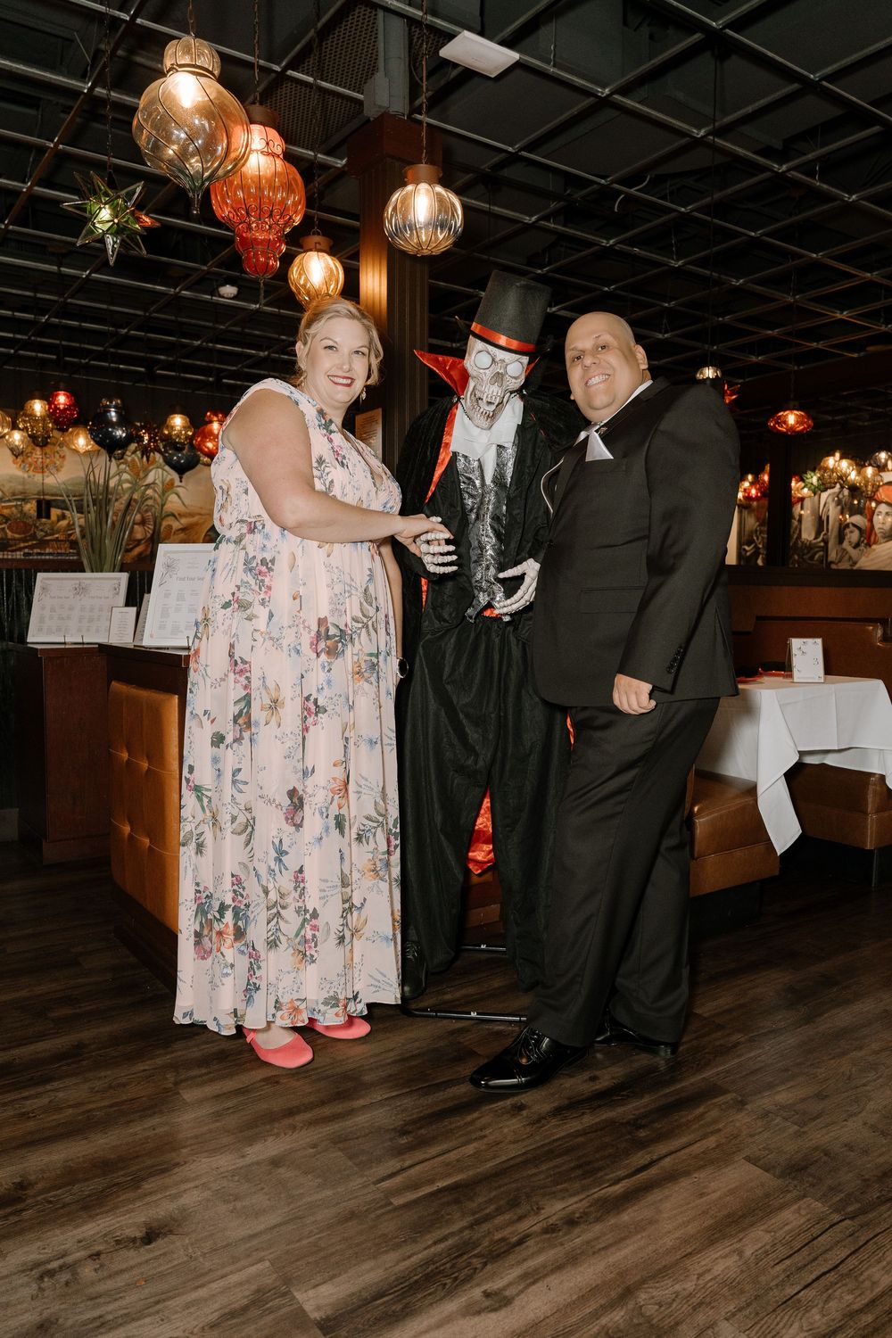 Couple dancing together on a wooden floor under warm pendant lighting at an indoor venue.