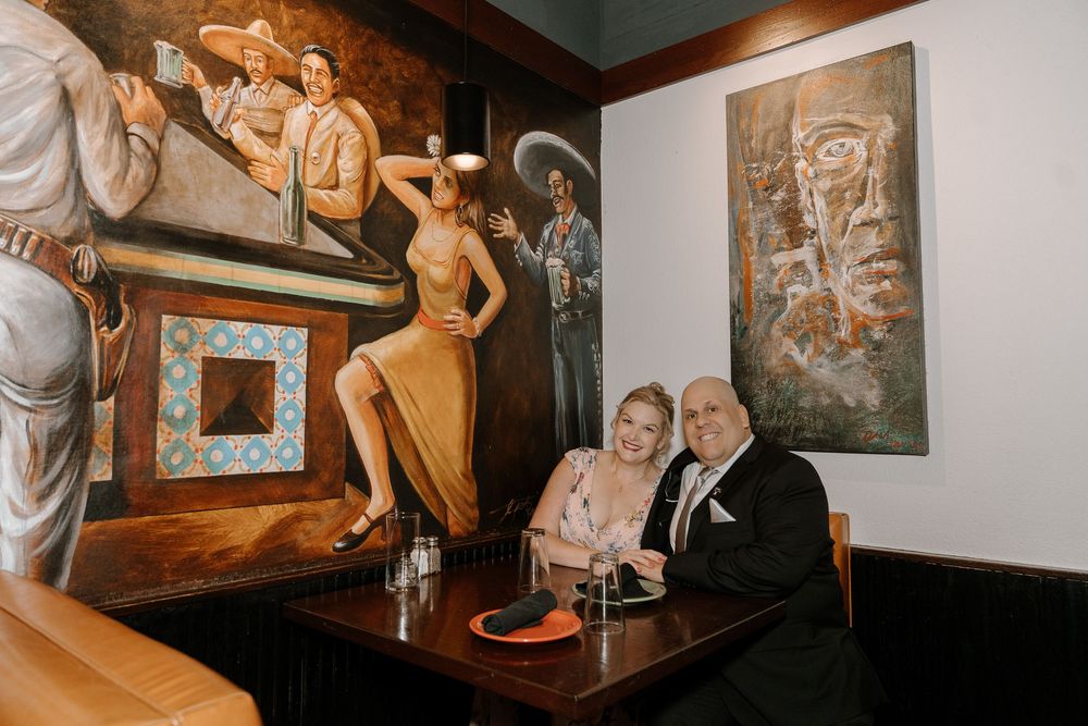 Vintage-style photographs and artwork decorate the walls of a cozy restaurant interior.