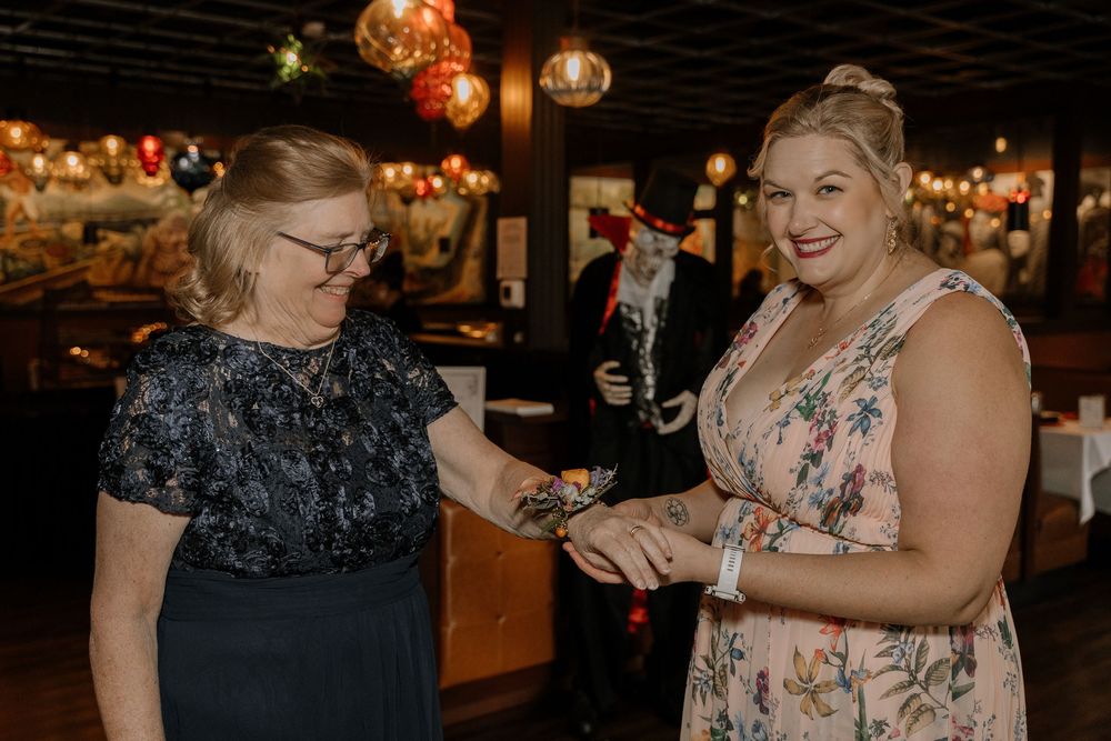 Two people sharing a celebratory moment at an evening event with string lights and decorative ambiance.