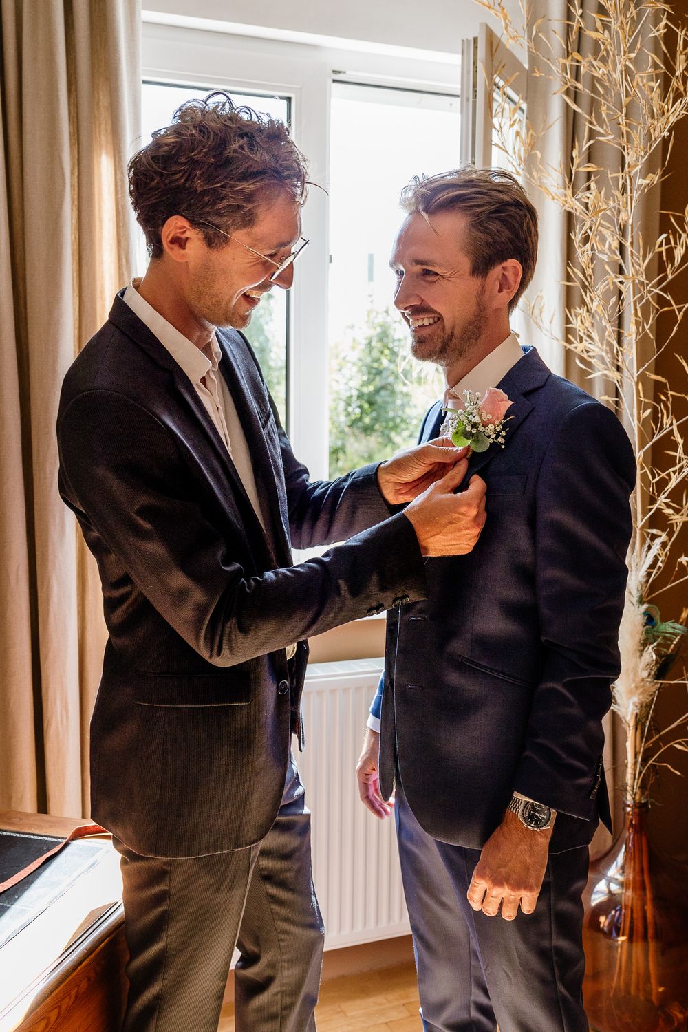 Photographe mariage Lille : capturer les instants complices entre un marie et son frere lors de l'habillage pendant les preparatifs du marie