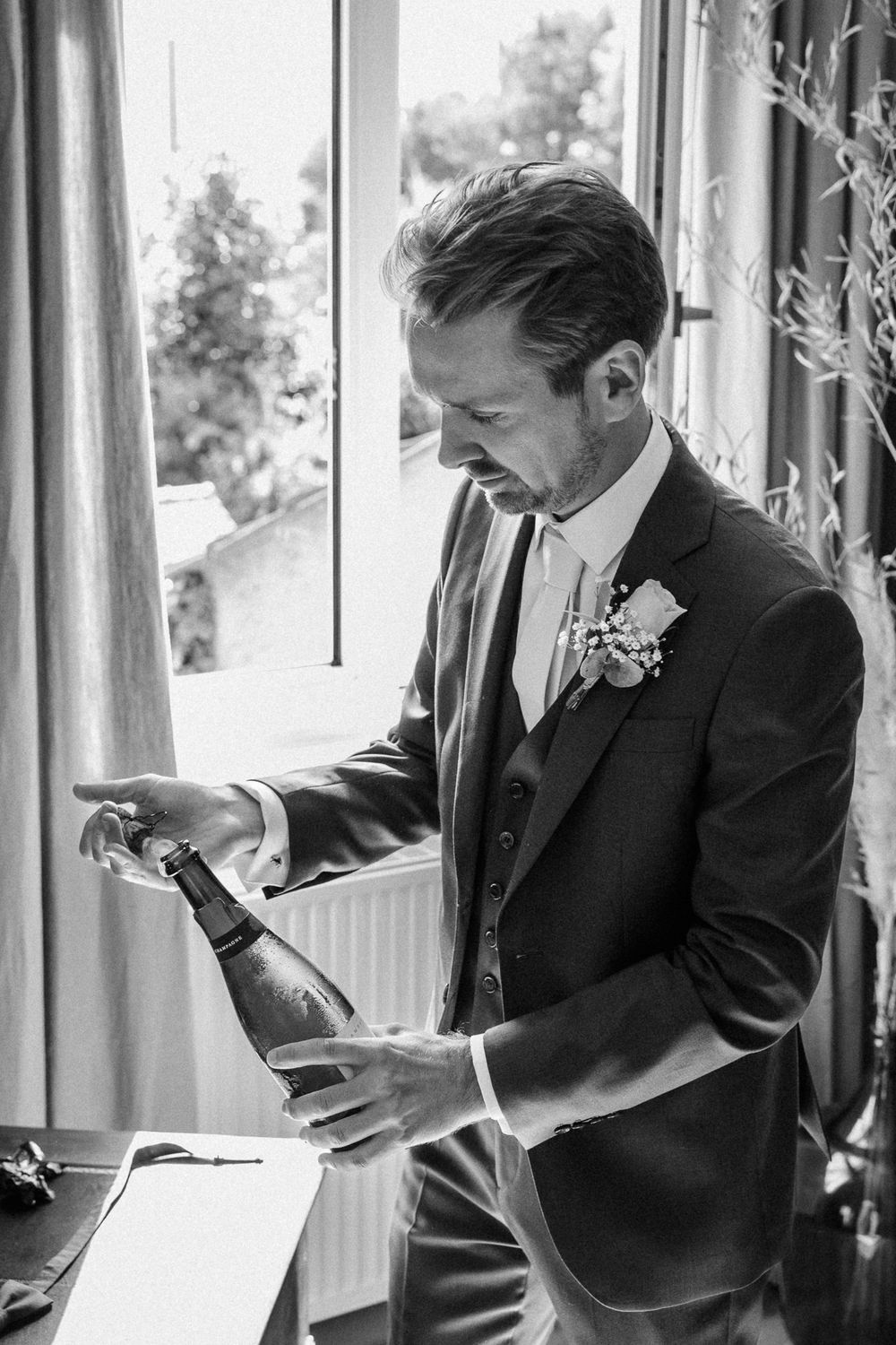 Reportage mariage Lille : marie debouche le champagne a la fin des preparatifs pour trinquer avec ses amis et sa famille avant la ceremonie.