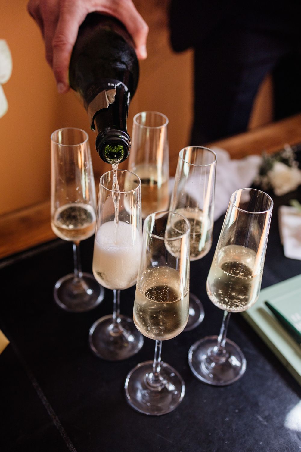 Reportage mariage Lille : le marie sert le champagne pendant ses preparatifs dans une belle maison de Lambersart