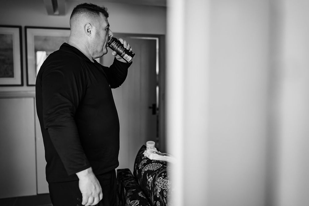 A black and white photo series showing someone wearing a black shirt in different poses against a light background.