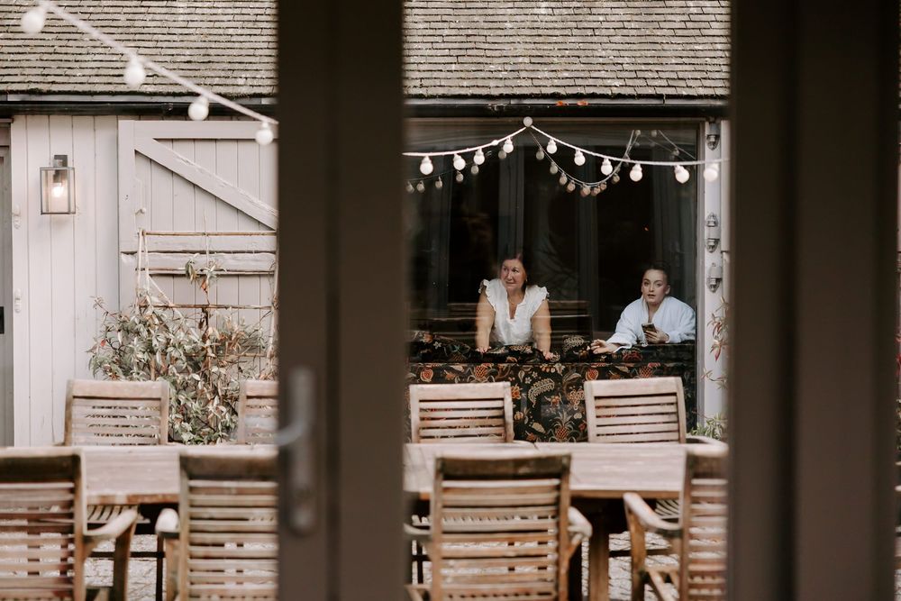 A rustic wooden porch decorated with string lights and cozy seating creates a warm and inviting outdoor living space.