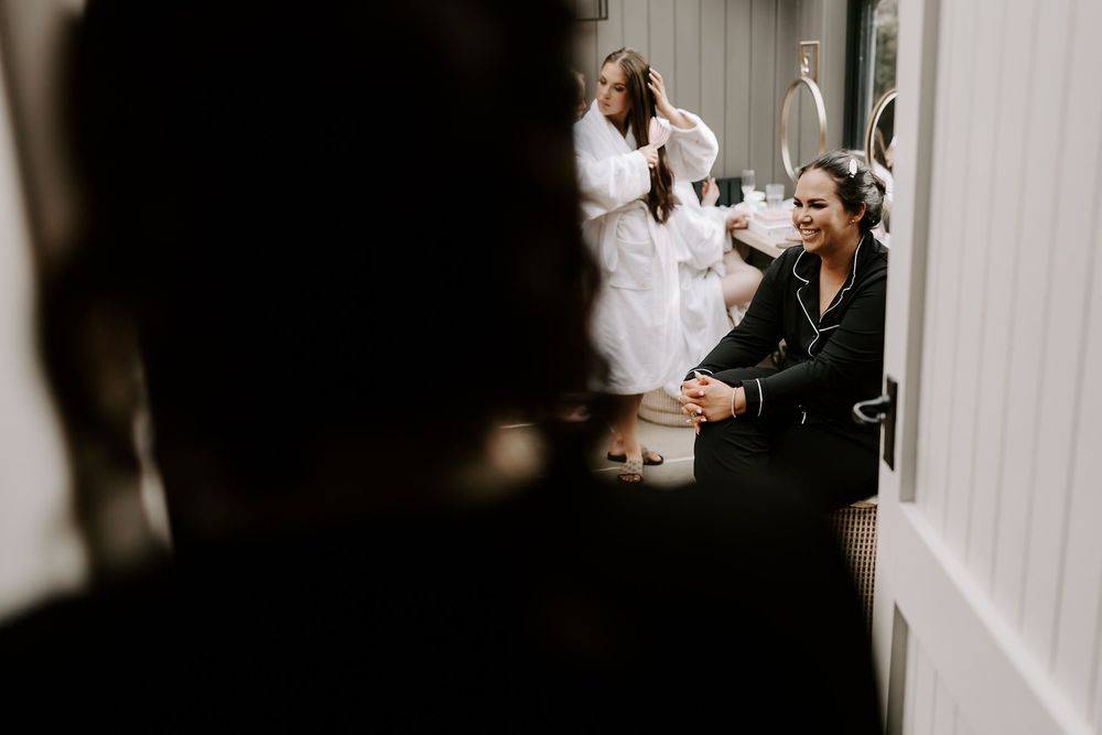 A couple shares an intimate moment in a dimly lit hallway during their wedding celebration.
