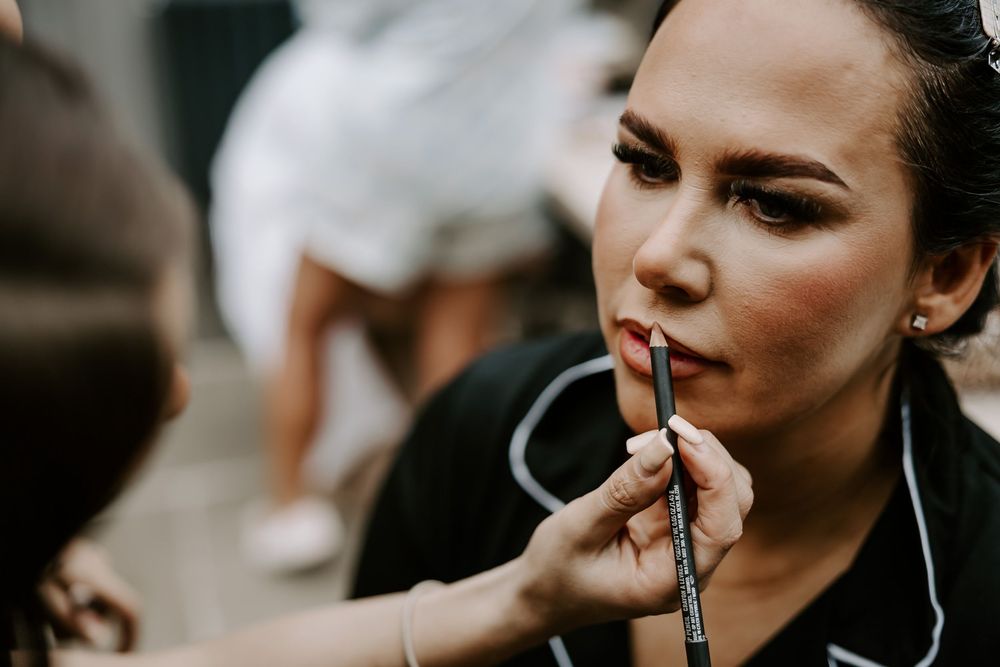 A series of close-up shots showing a woman applying lipstick in a dark, moody setting.