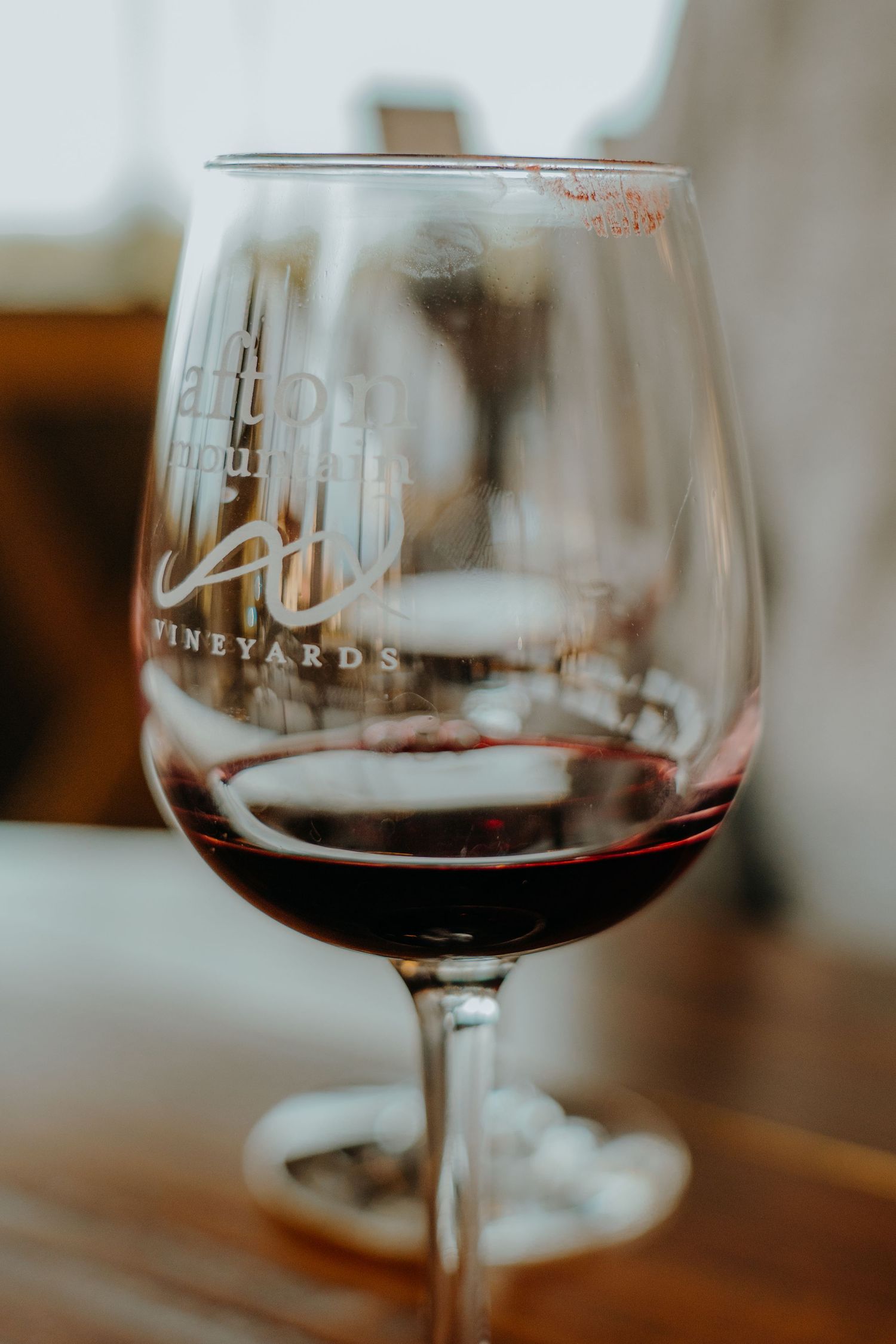 Close-up shot of red wine in elegant stemmed glasses at a winery tasting room.
