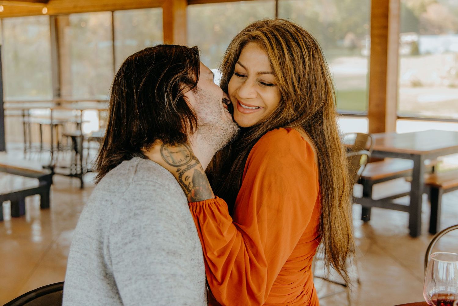 Two people enjoying an intimate conversation at a rustic winery.