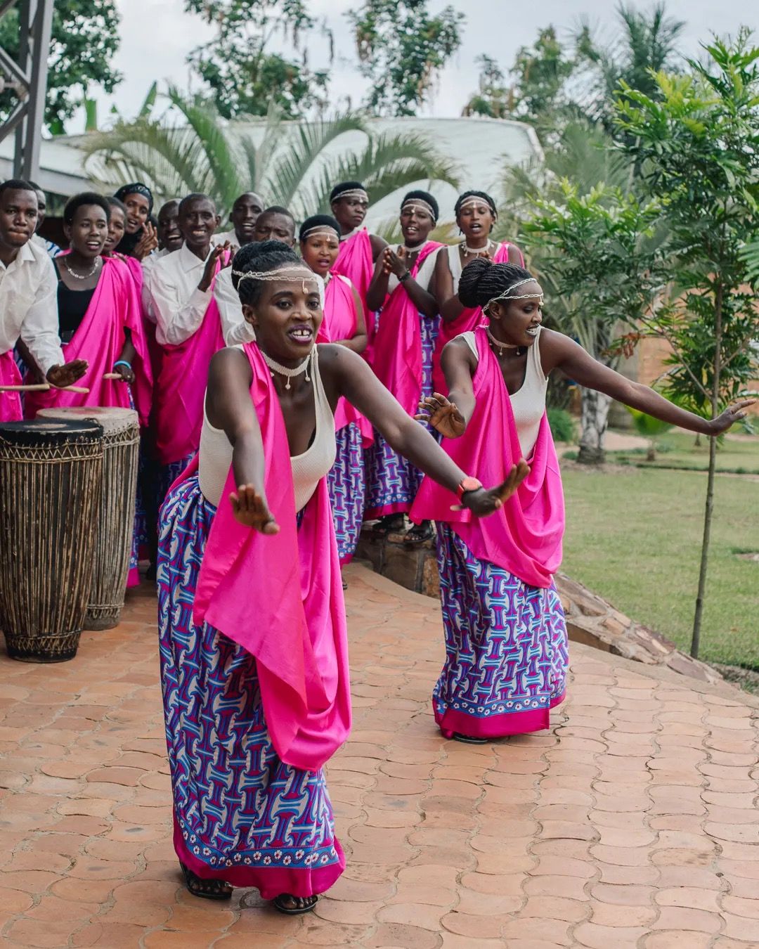 Women perform a traditional dance in bright pink dresses, celebrating culture, community and heritage.