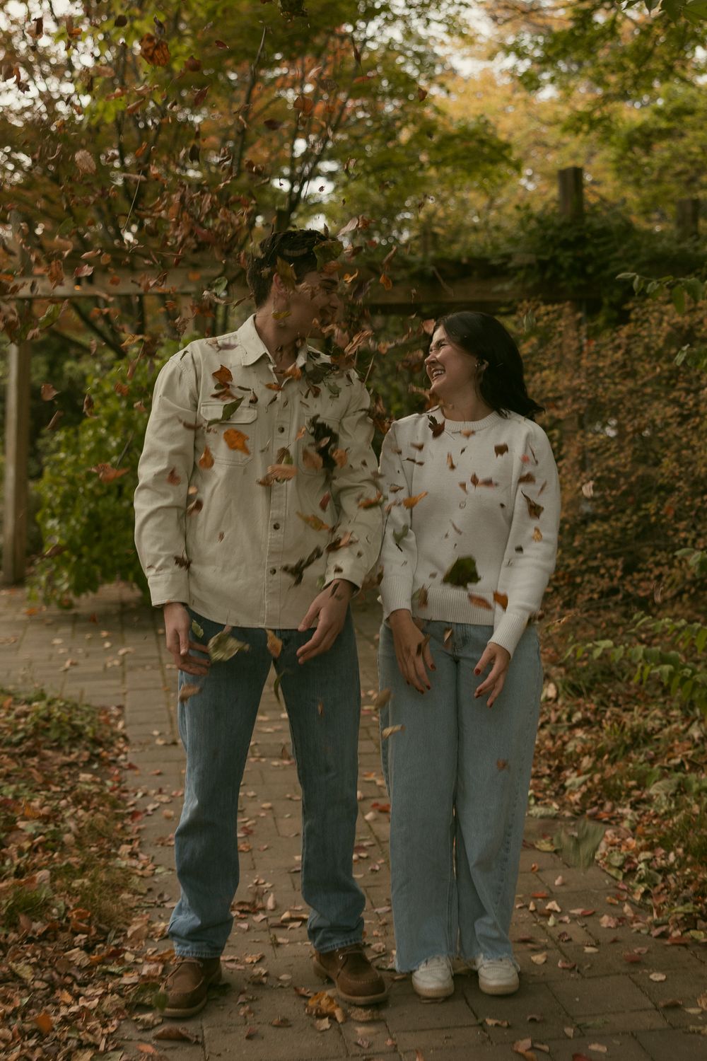 Matching outfits of denim and light colored tops in an autumn outdoor setting.