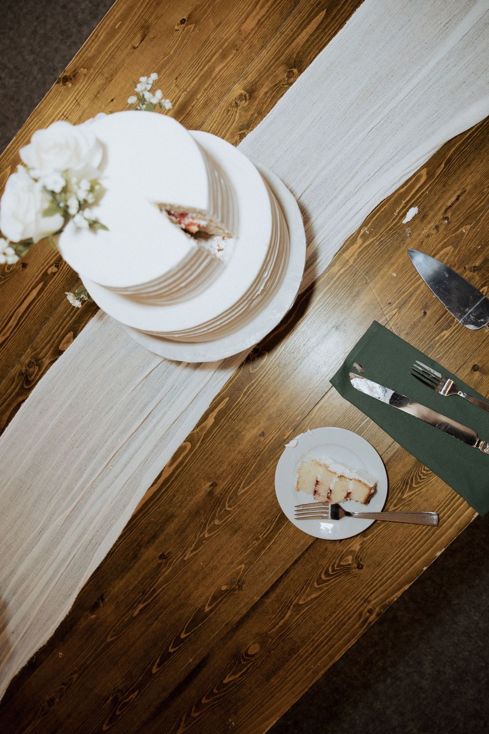 A white plate and silverware on a rustic wooden table shown in a sequence of four similar dining place settings.