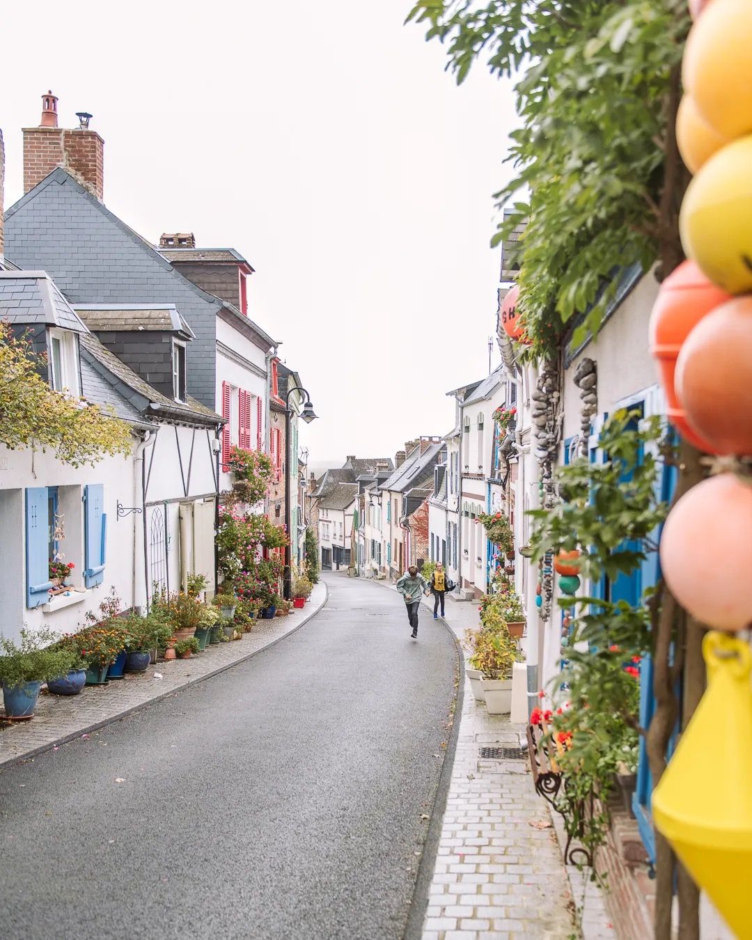Colourful coastal street decorated with balloons and pastel houses.