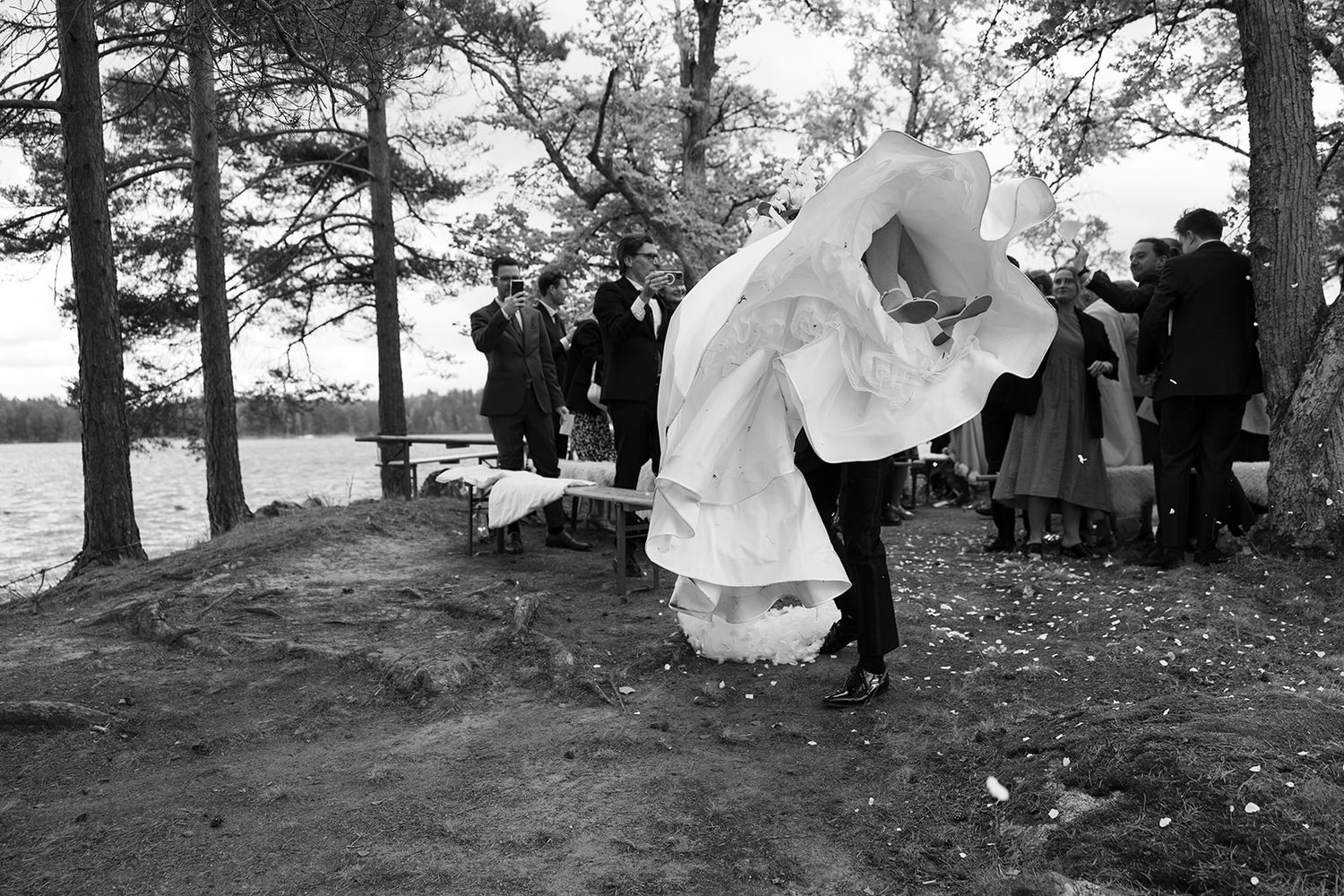 A series of black and white wedding photos showing celebratory moments during an outdoor ceremony.