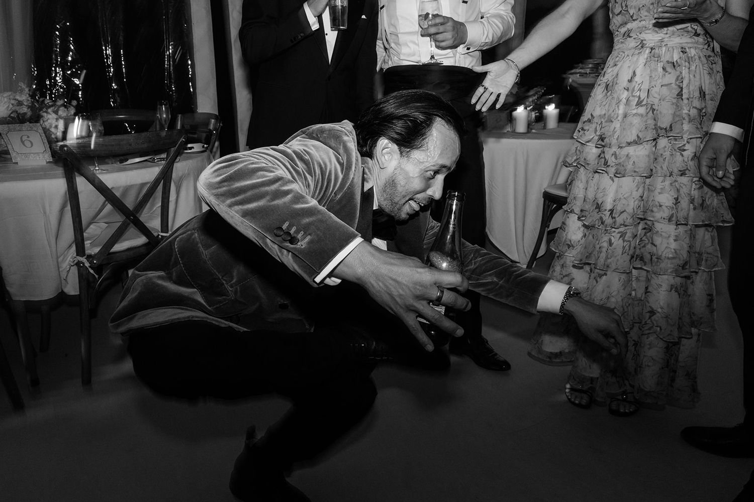 A black and white photo series showing people dancing and celebrating at what appears to be a wedding reception.