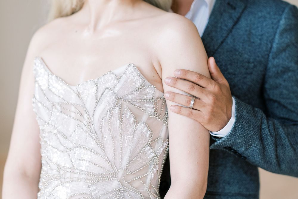 Close-up detail of a strapless white lace wedding dress bodice with an elegant floral pattern.