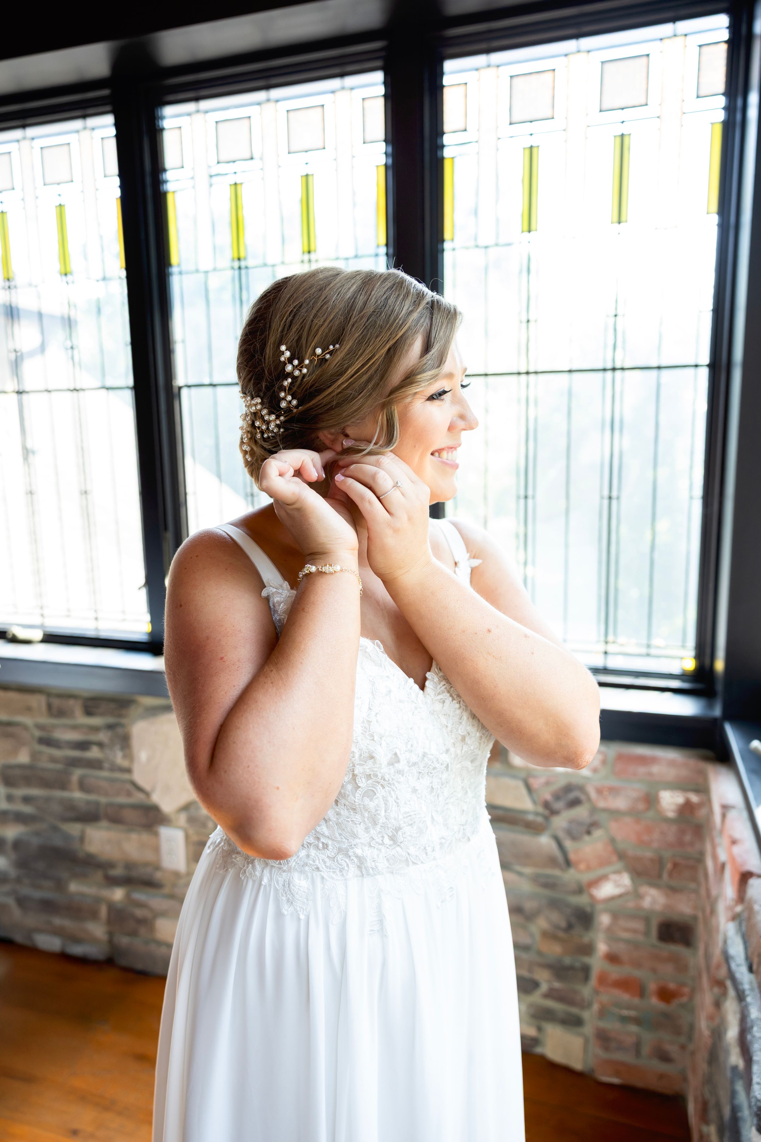 Bride in white lace dress stands emotionally in a sunny room. NJ wedding photographer | best NJ wedding photographer
