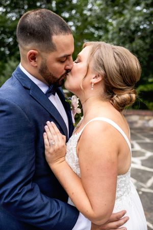 Multiple sequential photos show a newlywed couple sharing romantic kisses in outdoor setting.