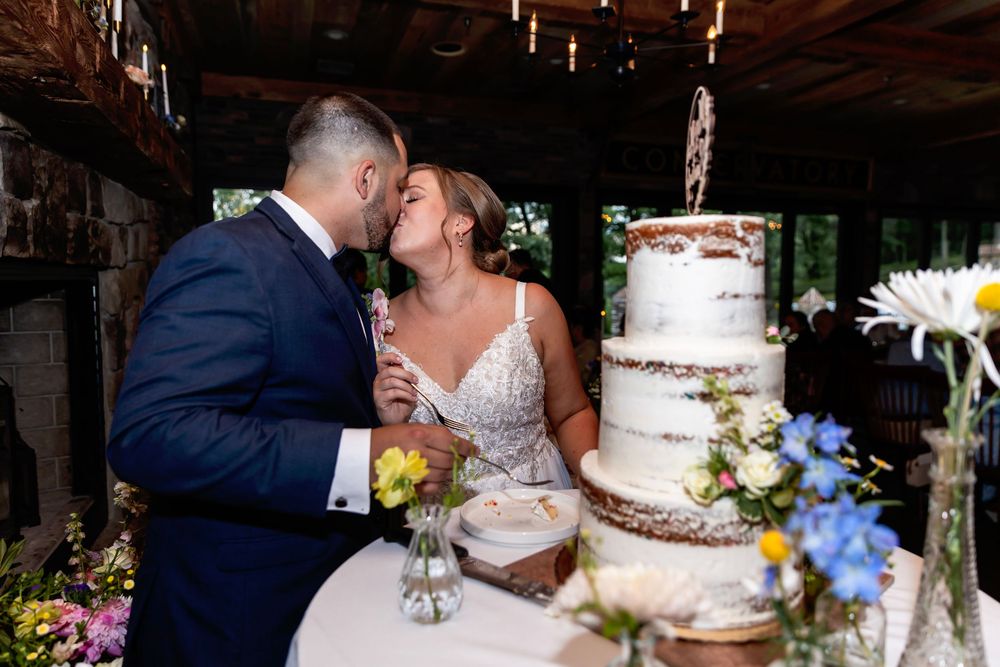 A romantic couple shares a kiss at a rustic venue during their wedding celebration. NJ wedding photographer | best NJ wedding photographer