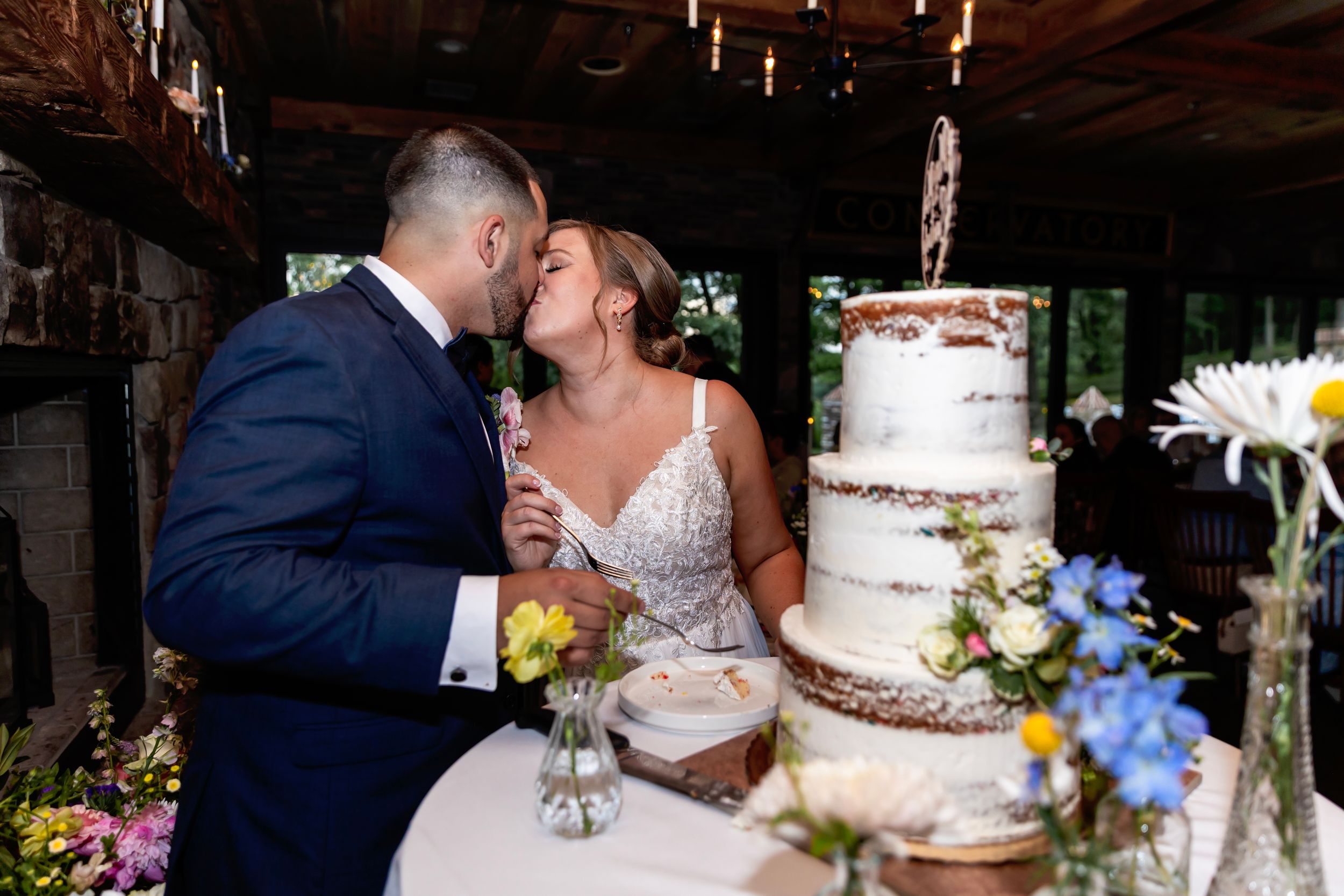 A romantic couple shares a kiss at a rustic venue during their wedding celebration. NJ wedding photographer | best NJ wedding photographer