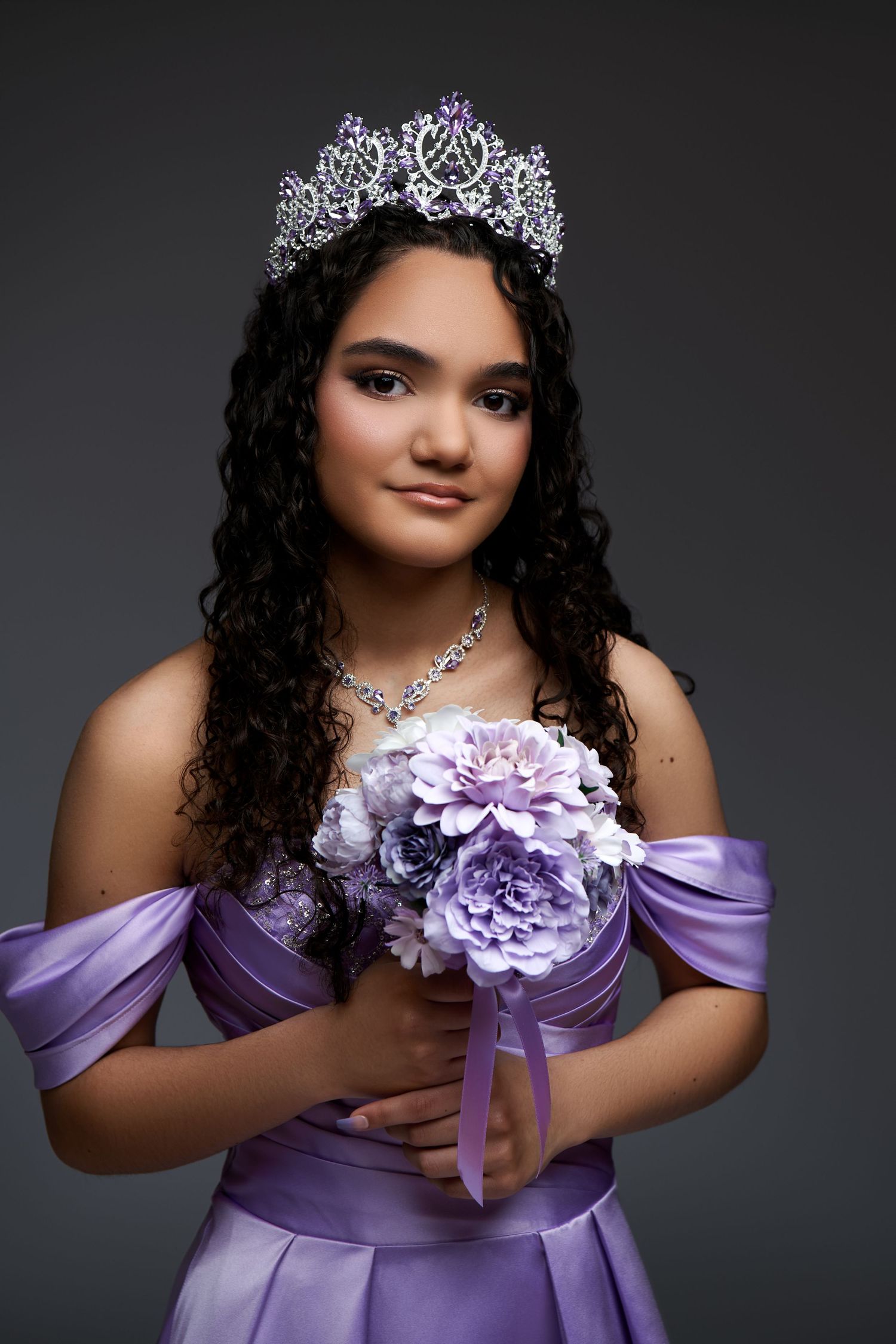 Portrait photos show a figure in a lavender off-shoulder gown wearing a tiara and holding purple flowers against dark background.