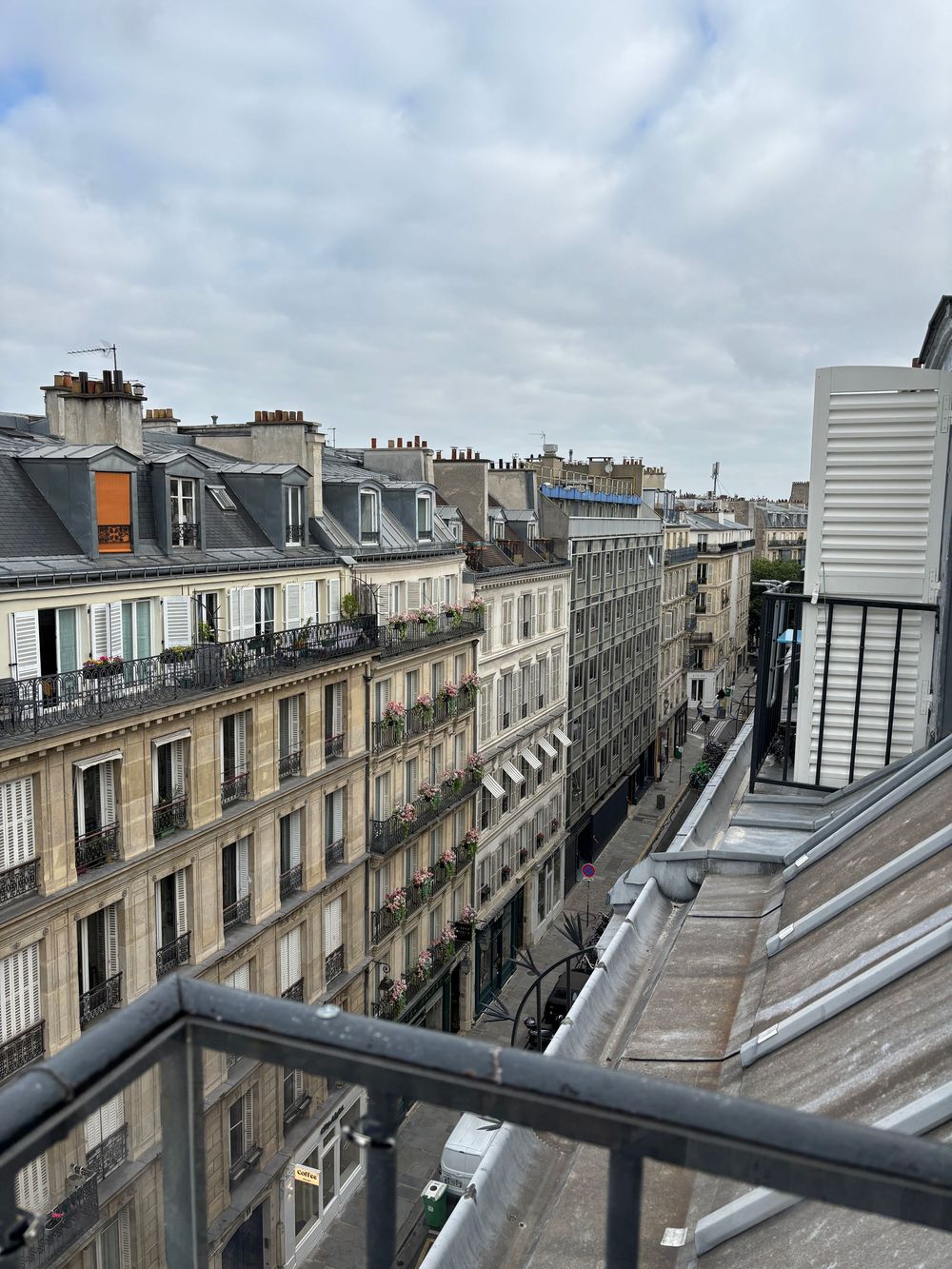 Urban view of classic Parisian architecture with rows of Haussmann-style buildings featuring mansard roofs and ornate facades.
