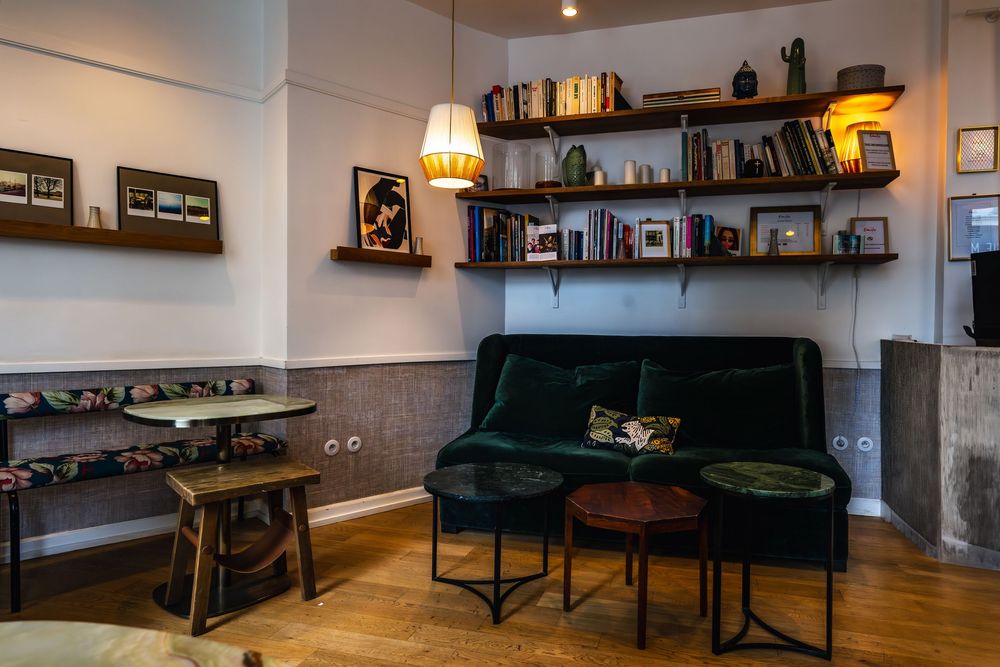 Modern basement living space with dark furniture, built-in shelving, and warm lighting creating a cozy atmosphere.