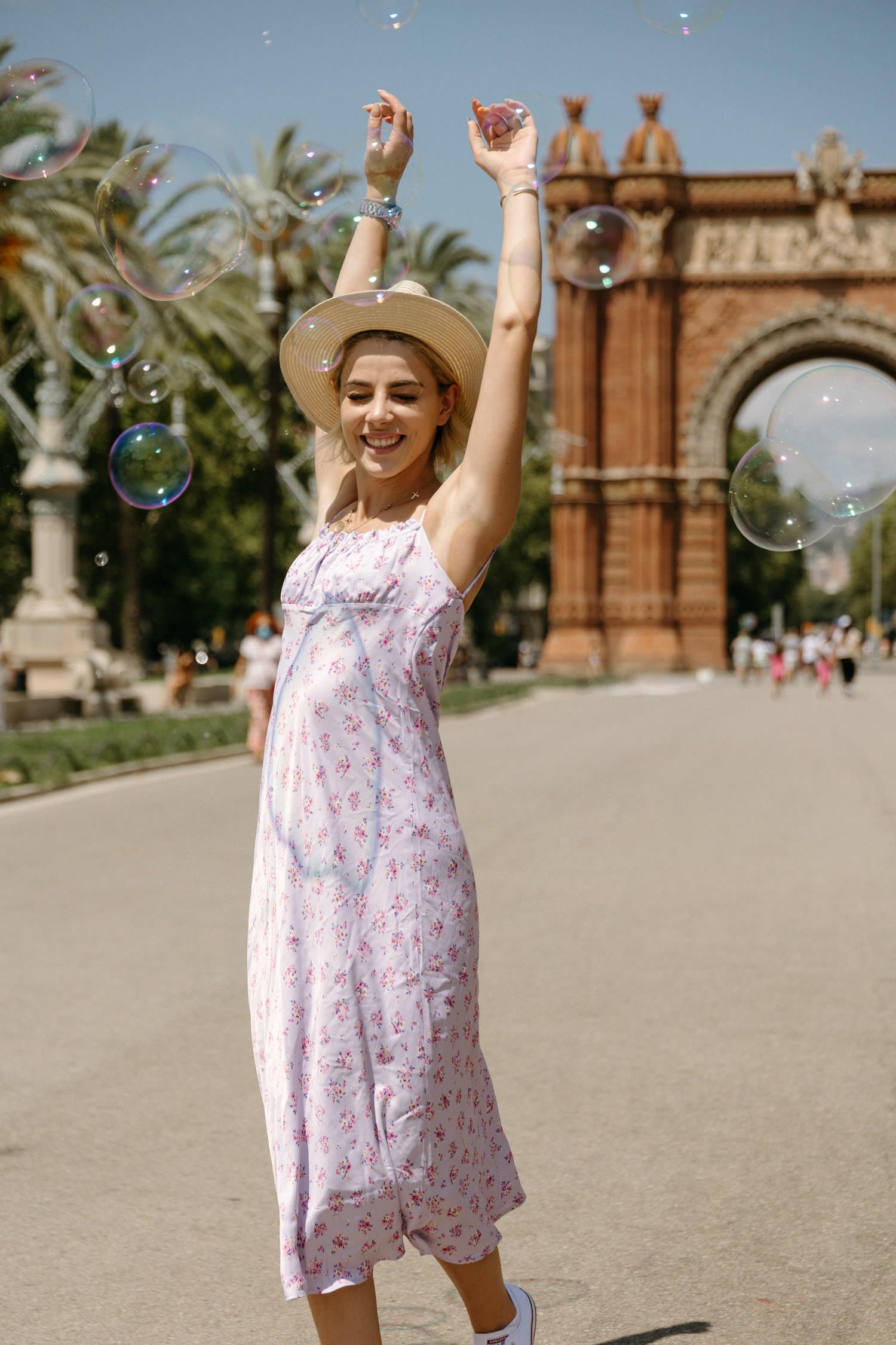 Joyful dancing with bubbles in front of the historic Arc de Triomf in Barcelona.