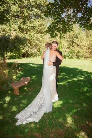 Couple sharing an intimate dancing moment in a sunlit garden setting during their wedding celebration.