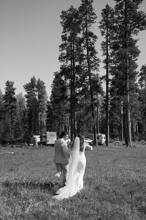 Black and white photo of a wedding ceremony in a forest meadow setting.
