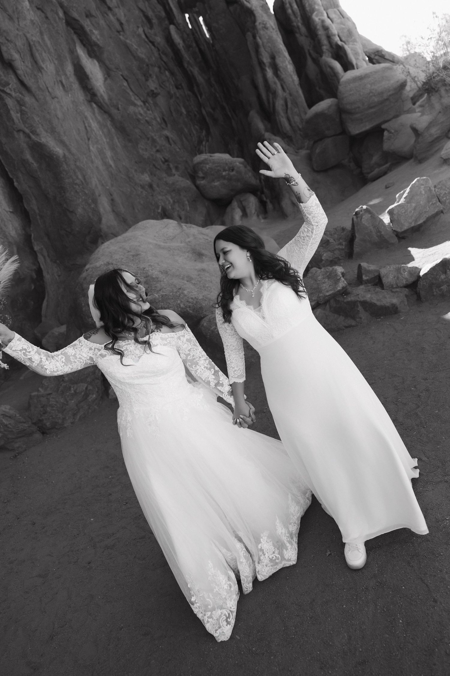 A sequence of black and white photos showing two people in white dresses sitting and falling backwards on rocks.