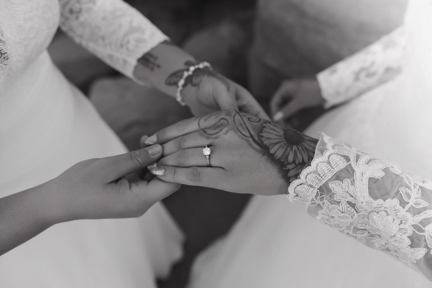 A close-up view of hands carefully writing with a pen on paper while wearing a white lace sleeve.