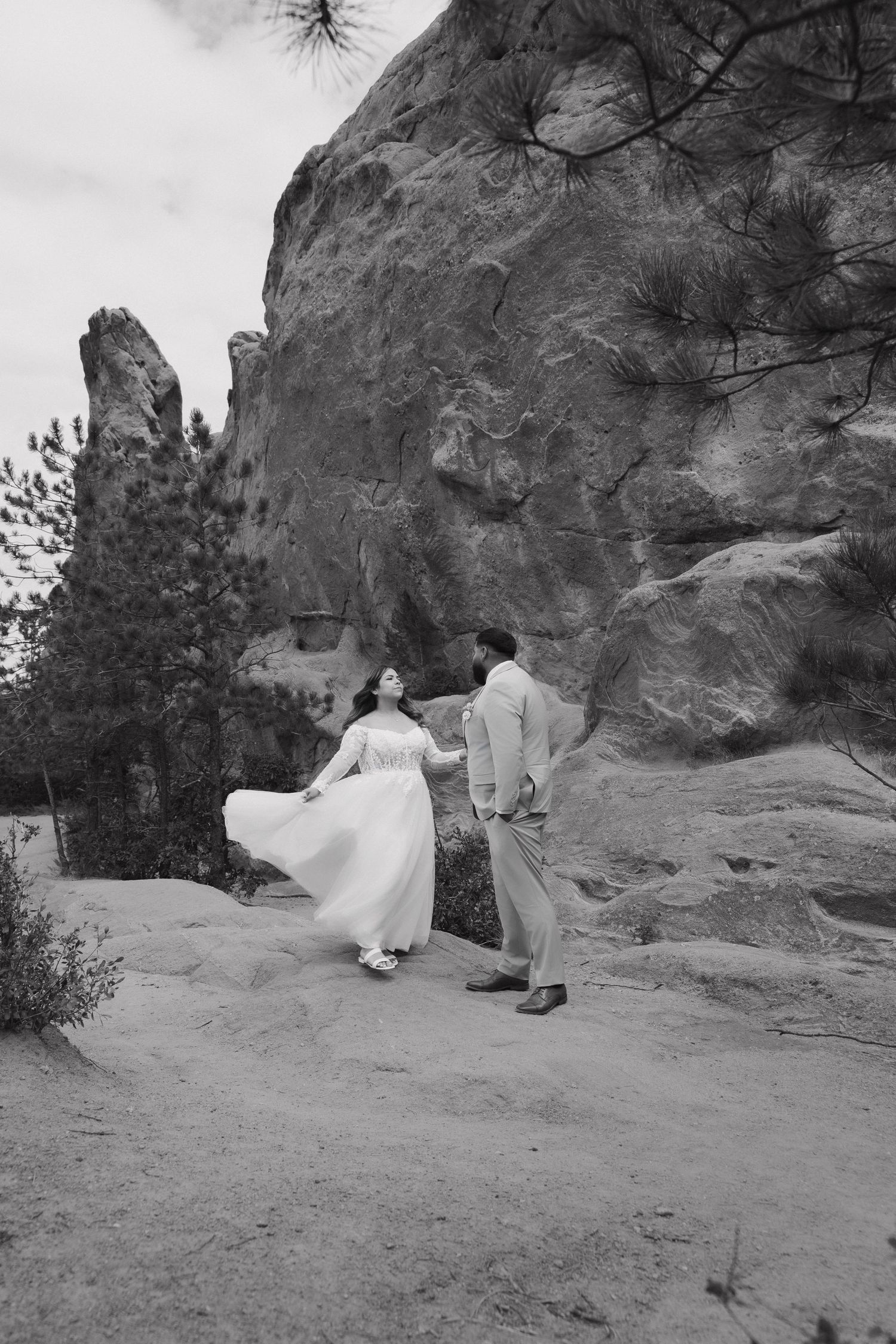 A romantic photoshoot sequence on rocky terrain with a flowing white dress against dramatic stone formations.