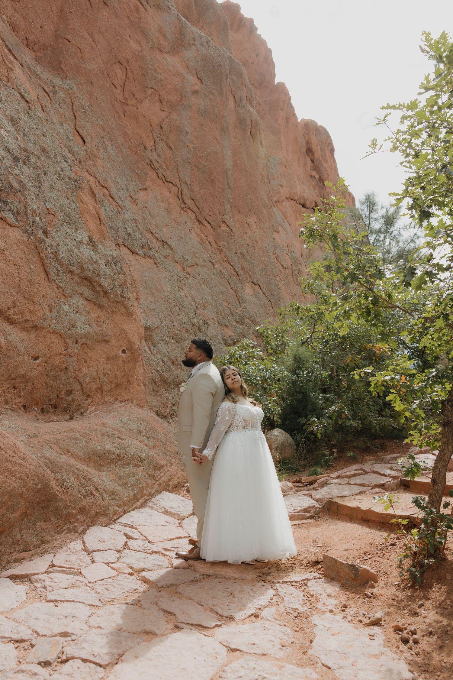 A wedding photography session against red rock formations with a white gown creating elegant silhouettes.
