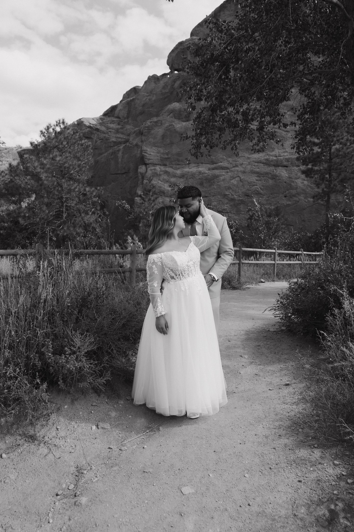 Black and white wedding photos of a couple walking along a mountain trail with dramatic landscape views.
