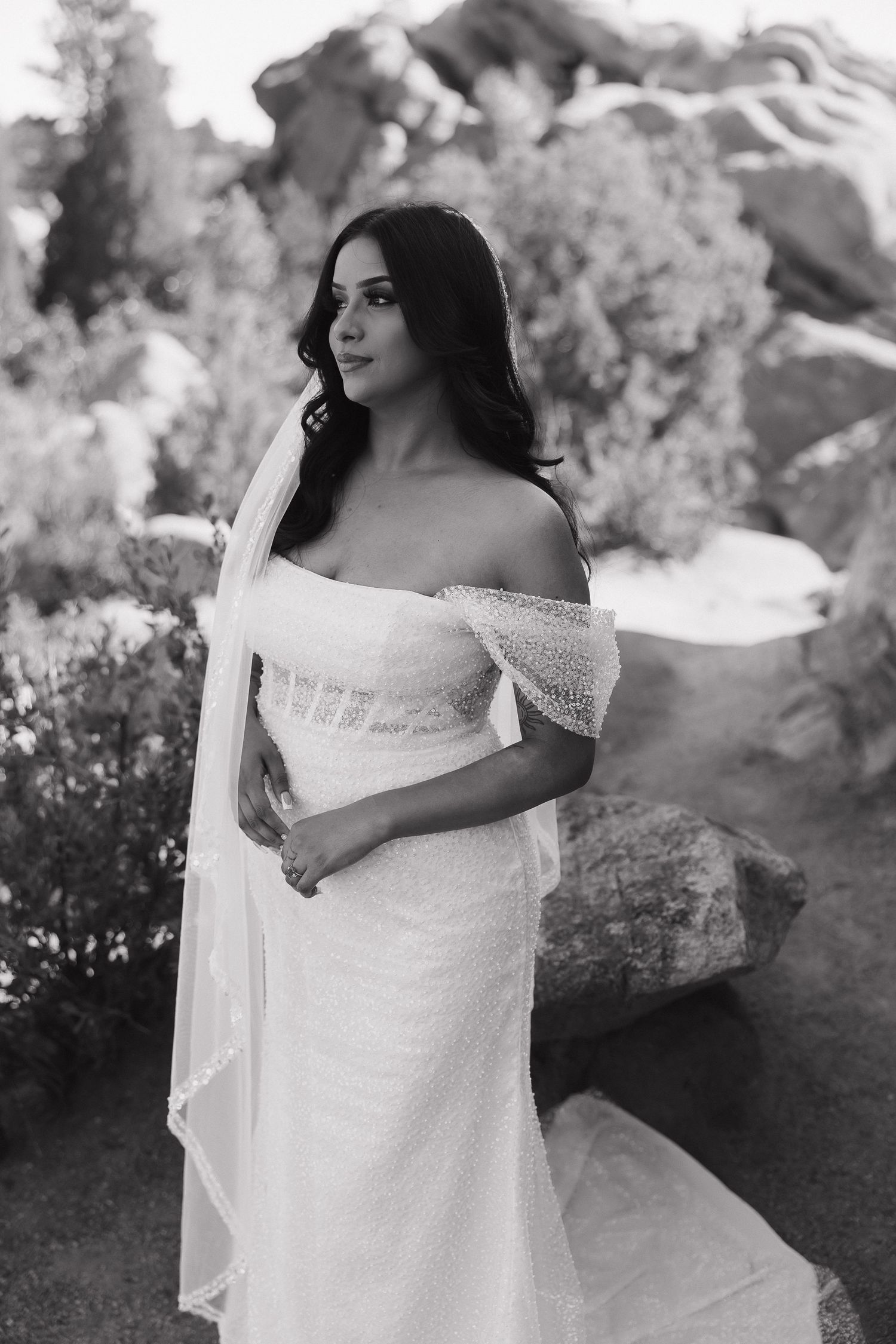 A romantic black and white photo series showing close-up details of a bride in a white lace wedding dress outdoors.