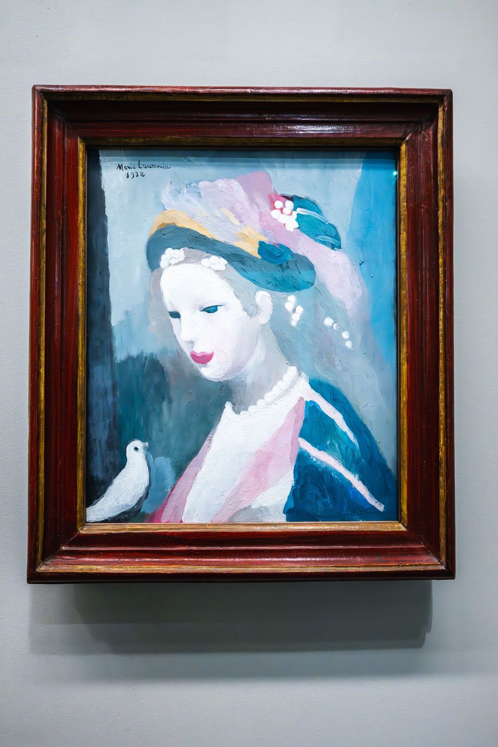 A framed artistic painting showing a figure in blue and pink tones with a decorative hat and a white bird against a dark background.