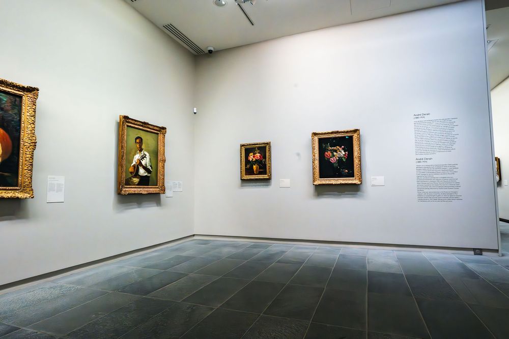 A series of art gallery interior views showing white walls with framed paintings and wooden floors in museum lighting.