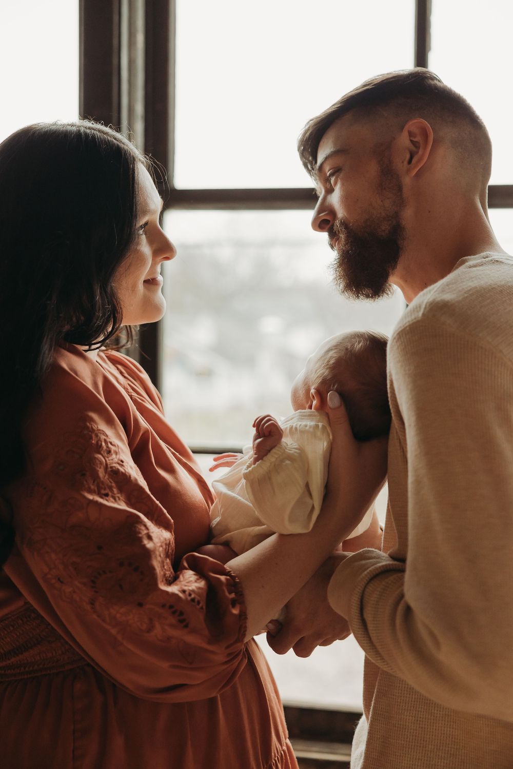 A couple shares a loving moment near a window in a warm, moody sequence of intimate romantic photos.