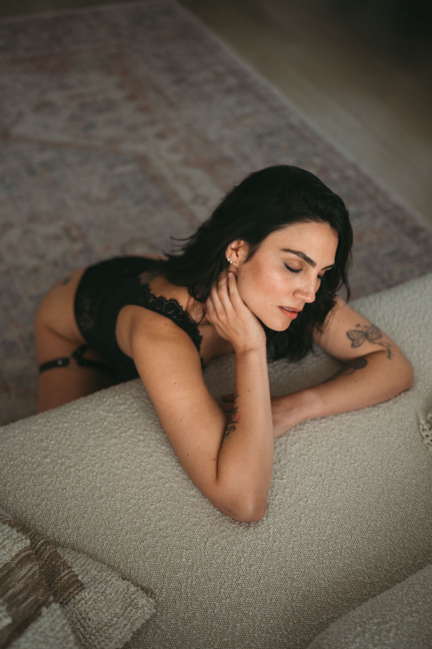 Intimate portrait session on textured carpet with moody lighting.