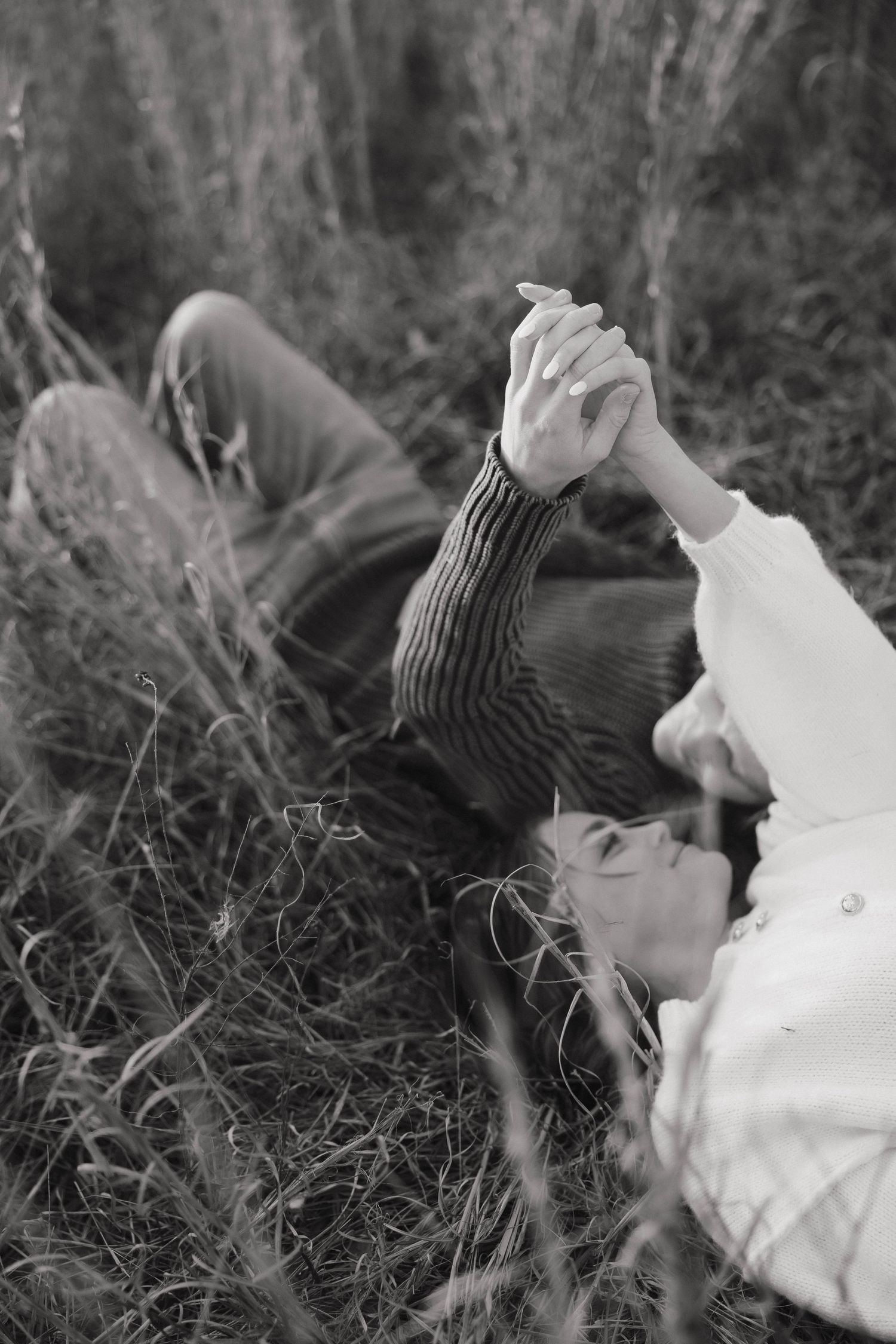Black and white artistic portrait of an intimate couple embracing in nature.