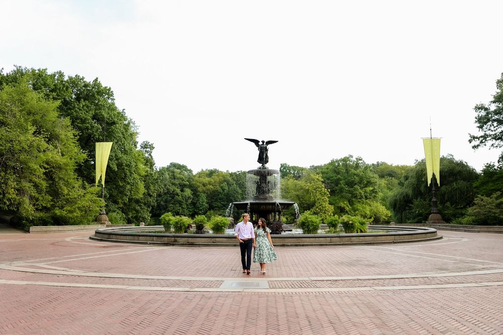 A couple walks together near Bethesda Fountain in Central Park on a sunny day.