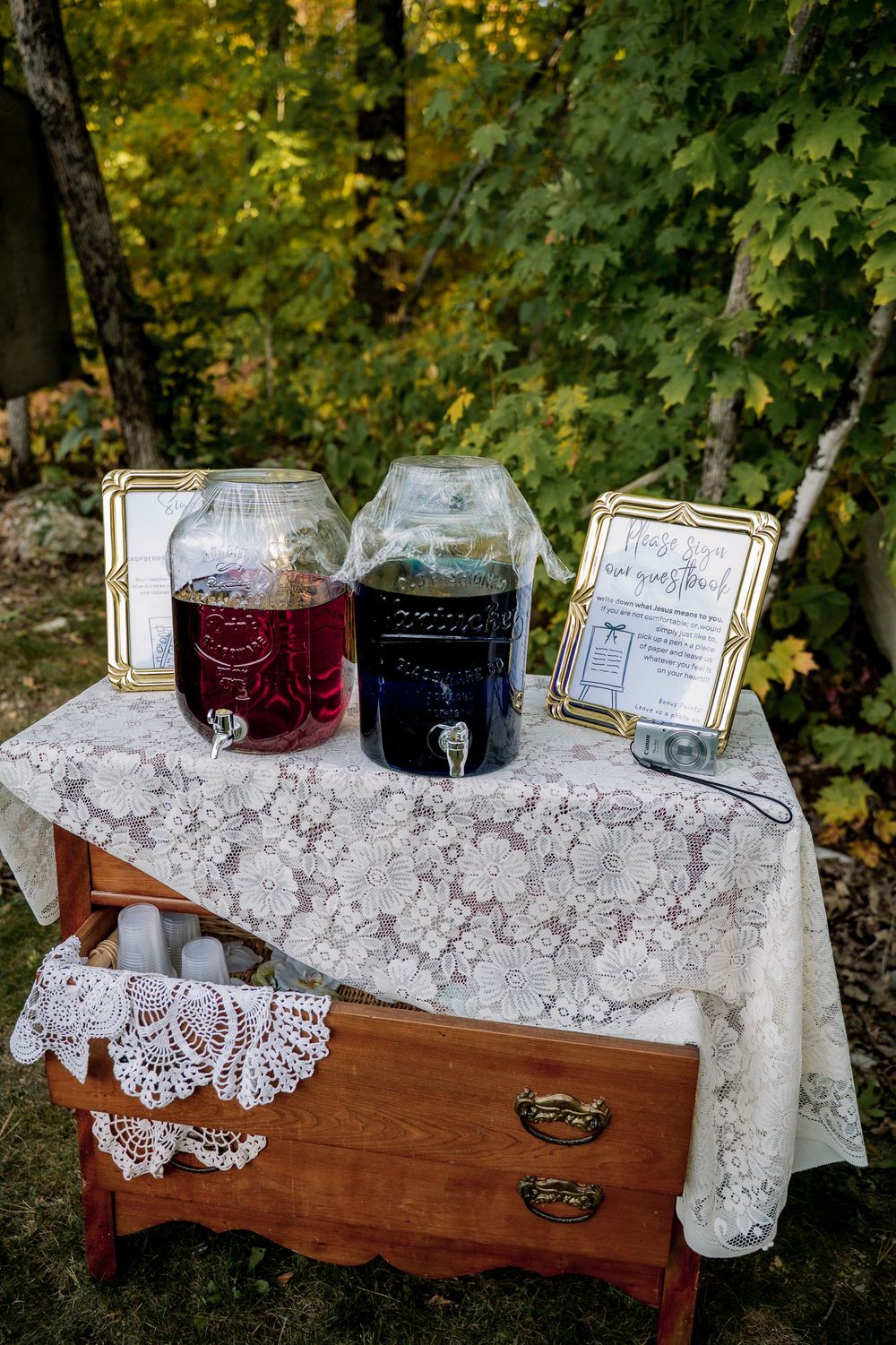 Elegant vintage table display with lace tablecloth and glass decanters for serving drinks.