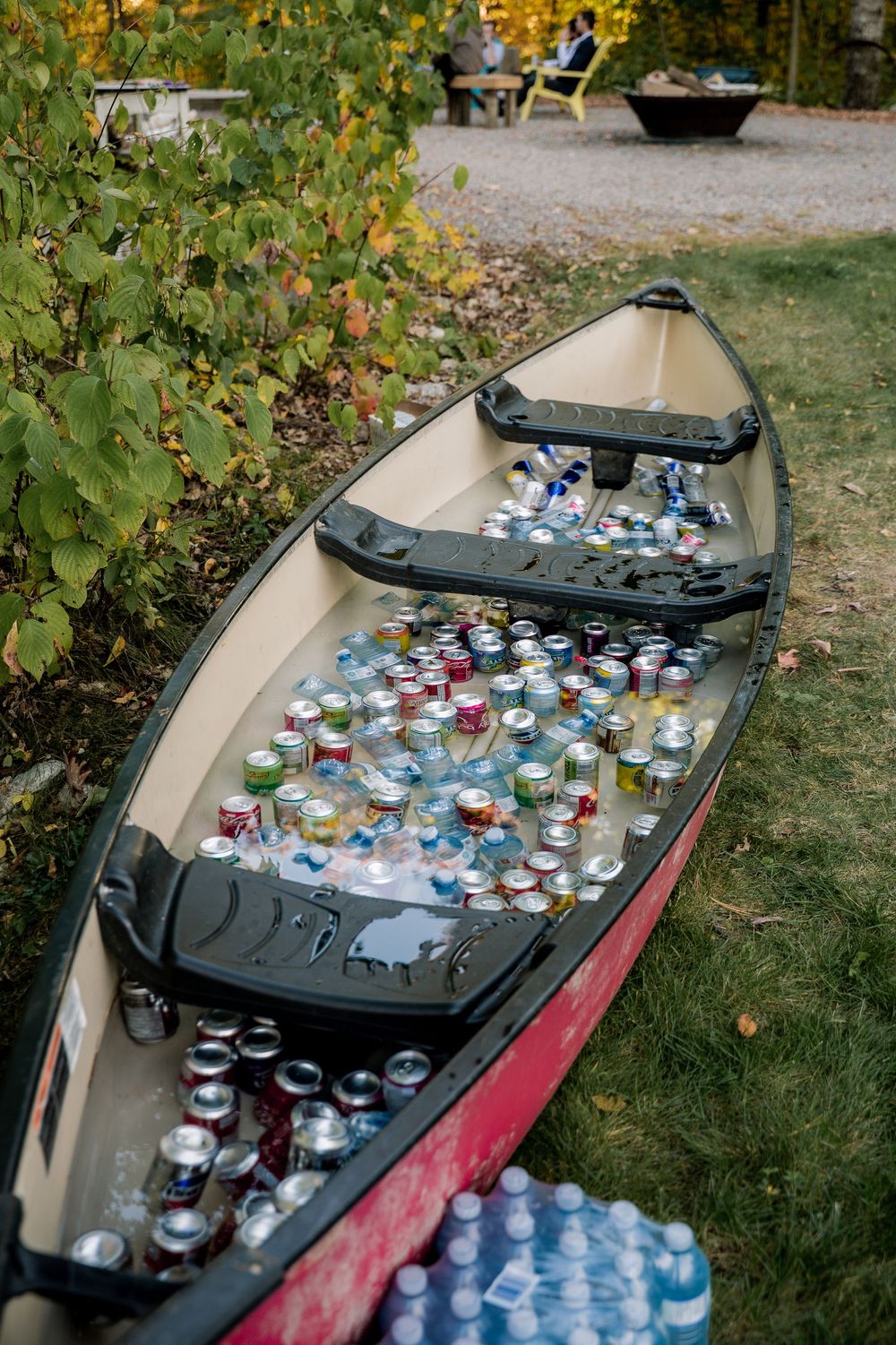 A rustic boat filled with drinks and beverages on ice for an outdoor party or event.